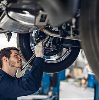 Auto car repair service center. Mechanic examining car suspension