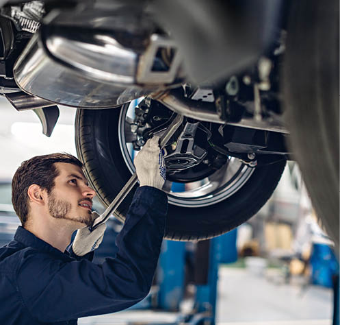 Auto car repair service center. Mechanic examining car suspension